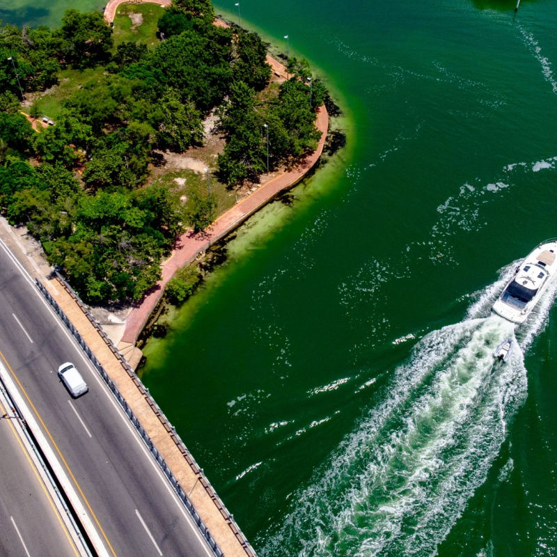 a small bridge in cancun with a boat and water