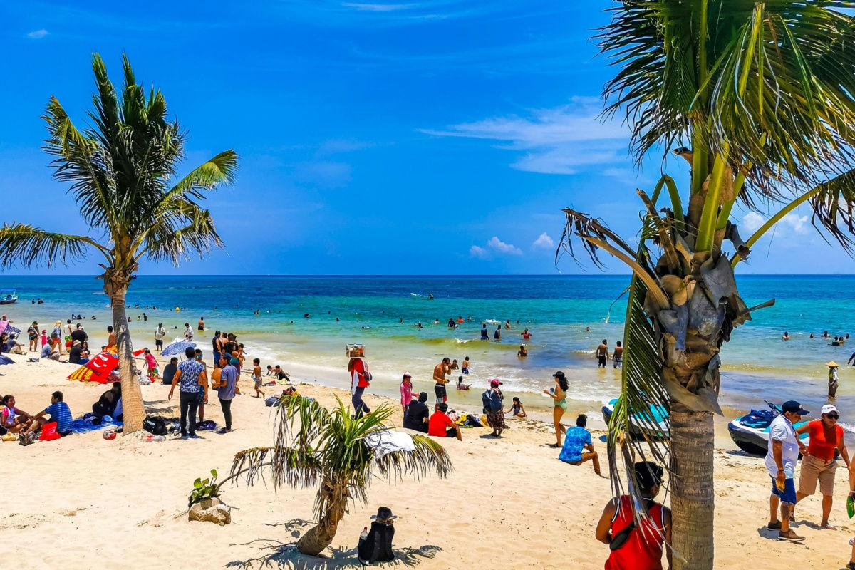 a white sand beach in playa del carmen with travelers 