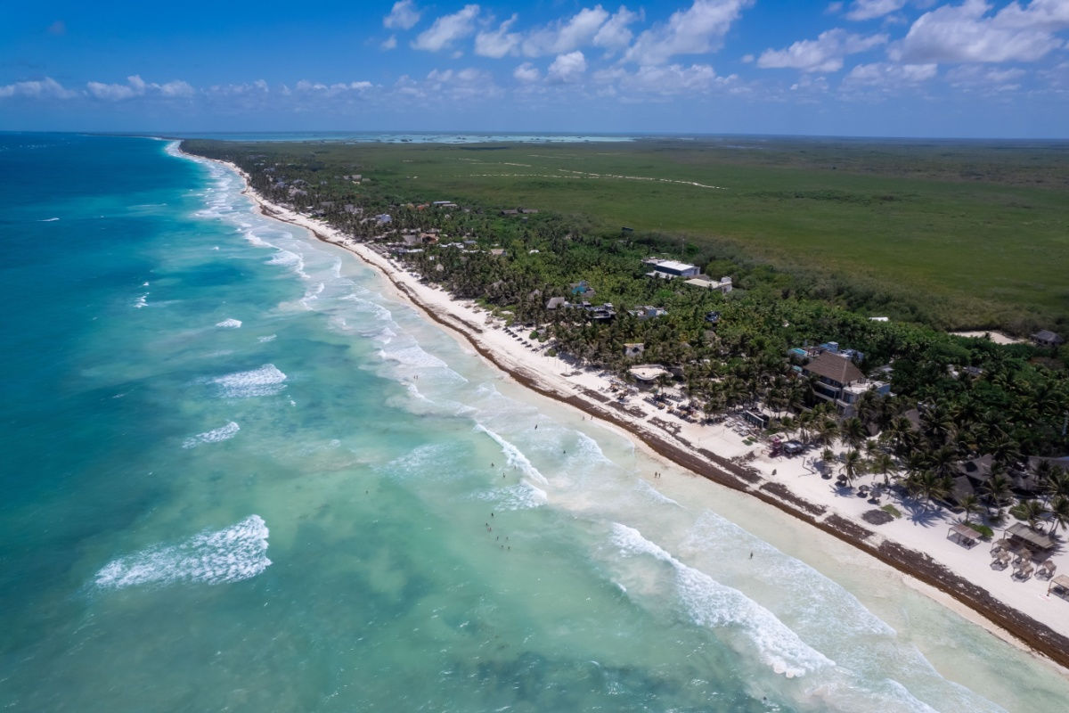 a white sand beach in tulum with crystal clear water