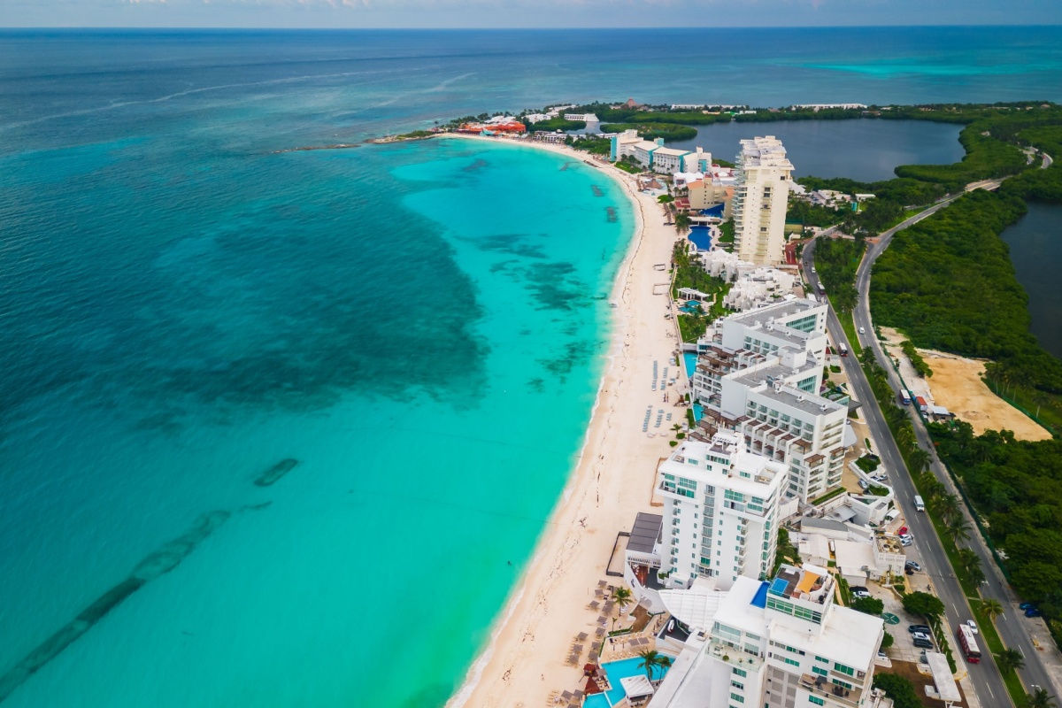 aerial view of a white sand beach in cancun lined with resorts