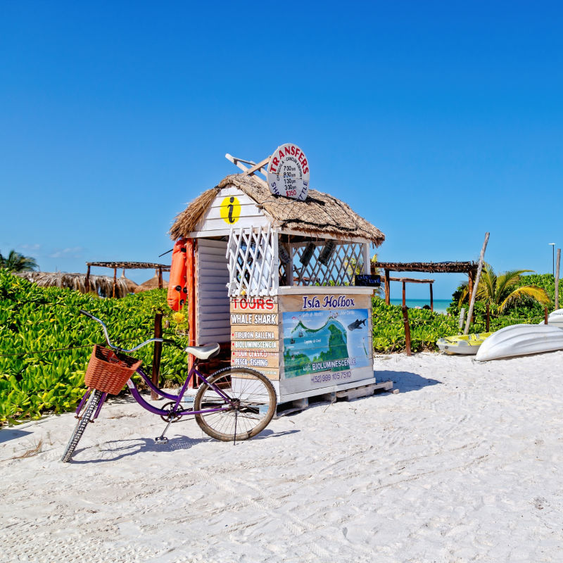 Bike on a Beach in Front of a Tour Sign in Holbox, Mexico