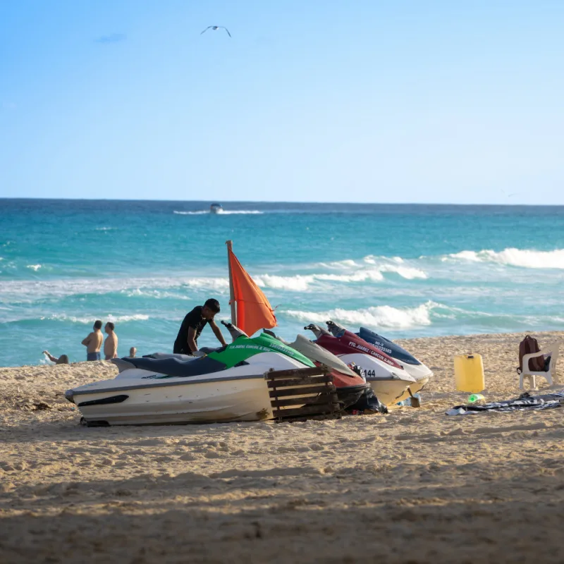 People Standing Around Jet Skis on a Cancun Beach