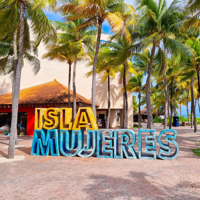 Isla Mujeres Sign on the Beach Surrounded by Palm Trees