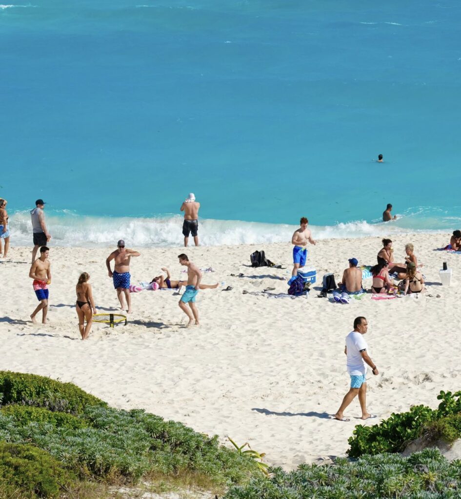 Tourists on white sand beach cancun