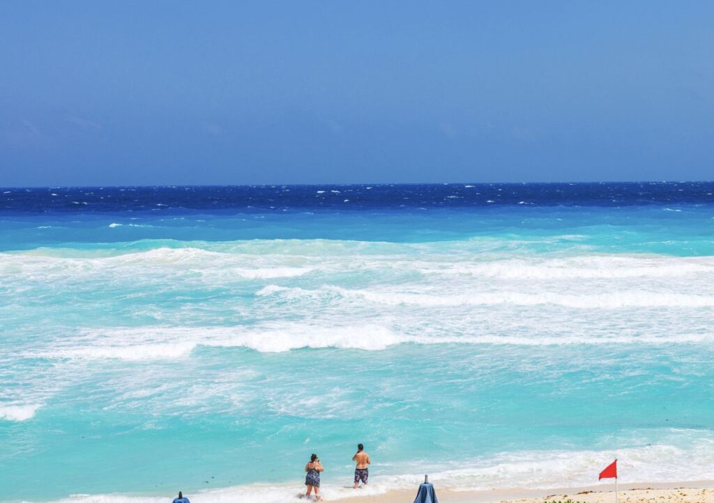 Red flag Cancun beach swimmers knee deep