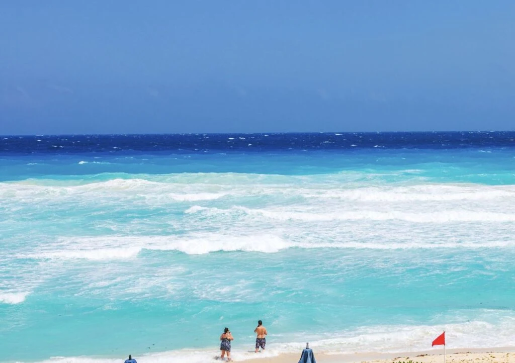 Red flag Cancun beach swimmers knee deep