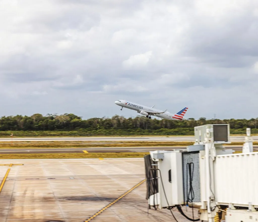 American Airlines aircraft taking off at Cancun airport against blue sky with white clouds. Cancun. Mexico