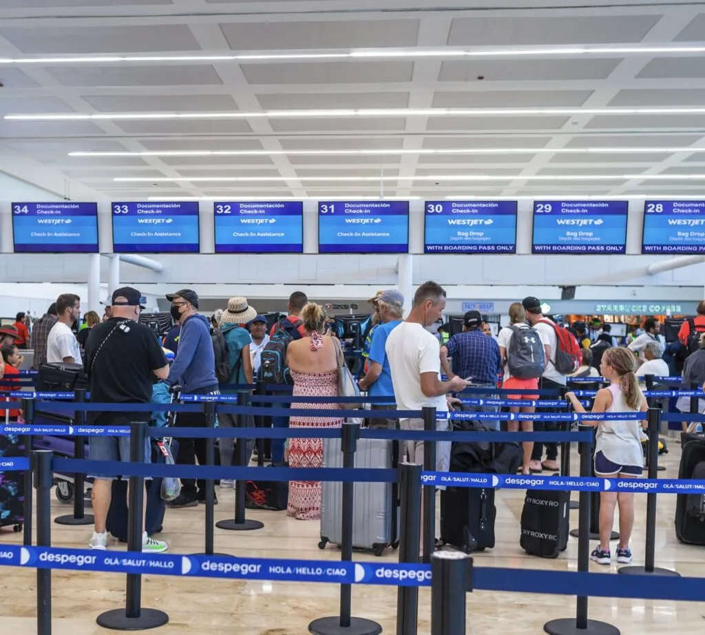 Passengers Wait in Line to check in for flights at cancun airport