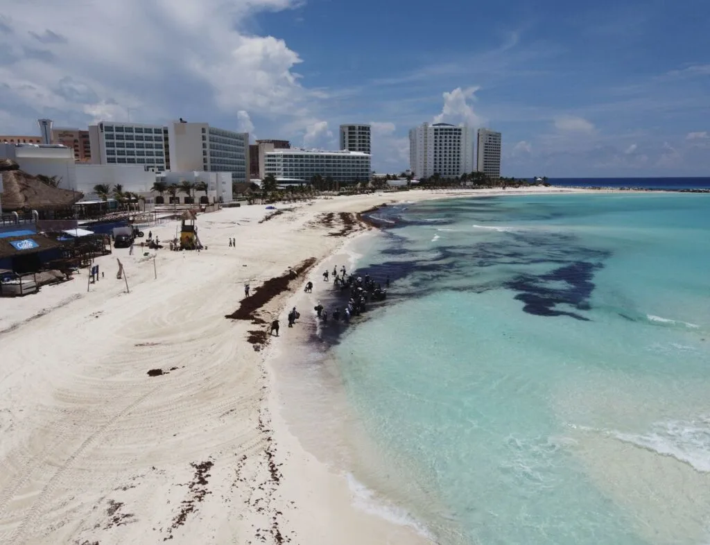 ancun, Quintana Roo, Mexico, June 12, 2020.- Workers clean sargassum on a beach in Cancun, the sargassum stain can be seen from the air