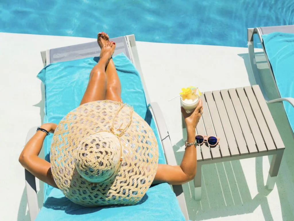Woman drinks virgin pina colada by pool in cancun