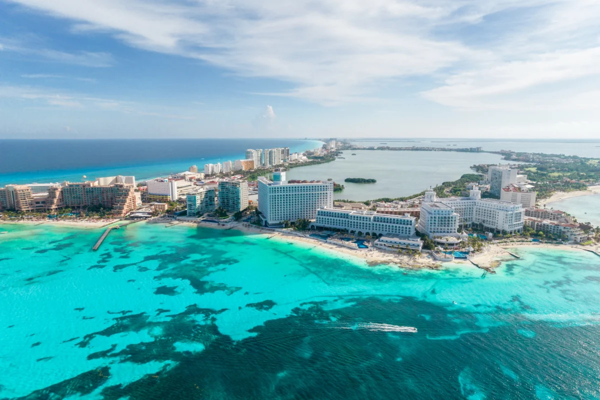 Aerial view of Cancun Hotel Zone with resorts lining the coast on a beautiful day
