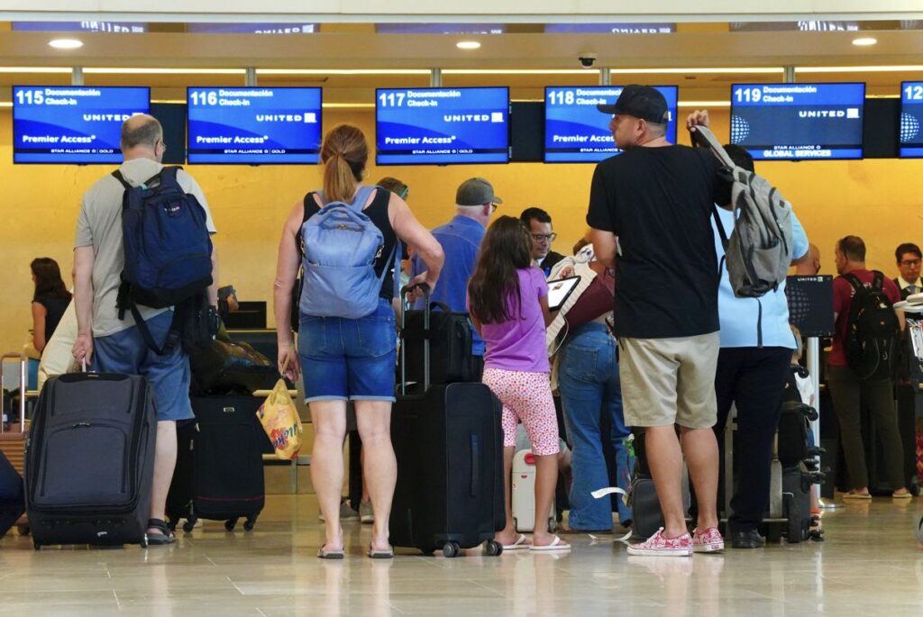 Travelers wait in line at Cancun Airport