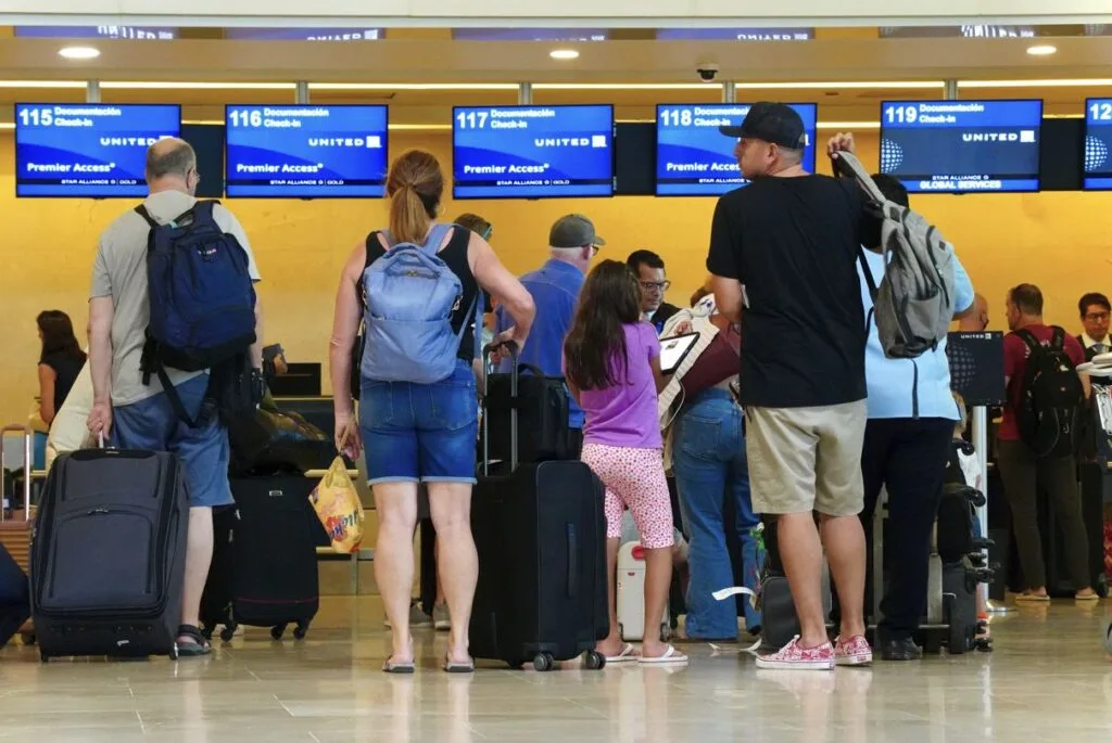 Travelers wait in line at Cancun Airport