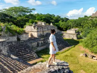 Ek Balam Mayan ruins in Mexico with woman standing on the ruins