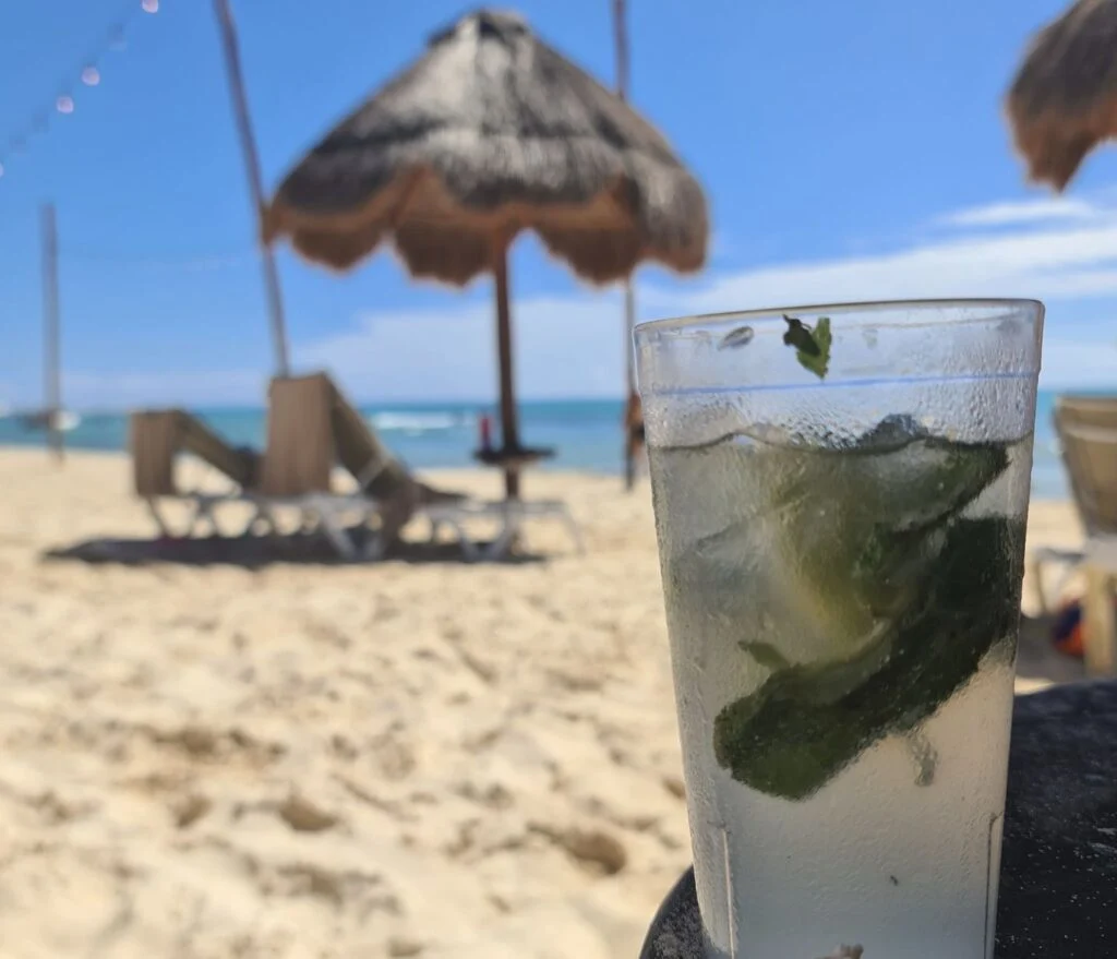 Mojito in plastic cup on the sand