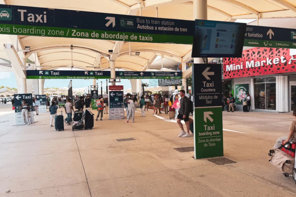 Area just outside of Cancun Airport Terminal with mini market and taxi drivers and pickups waiting
