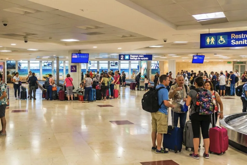 travelers wait at luggage collection