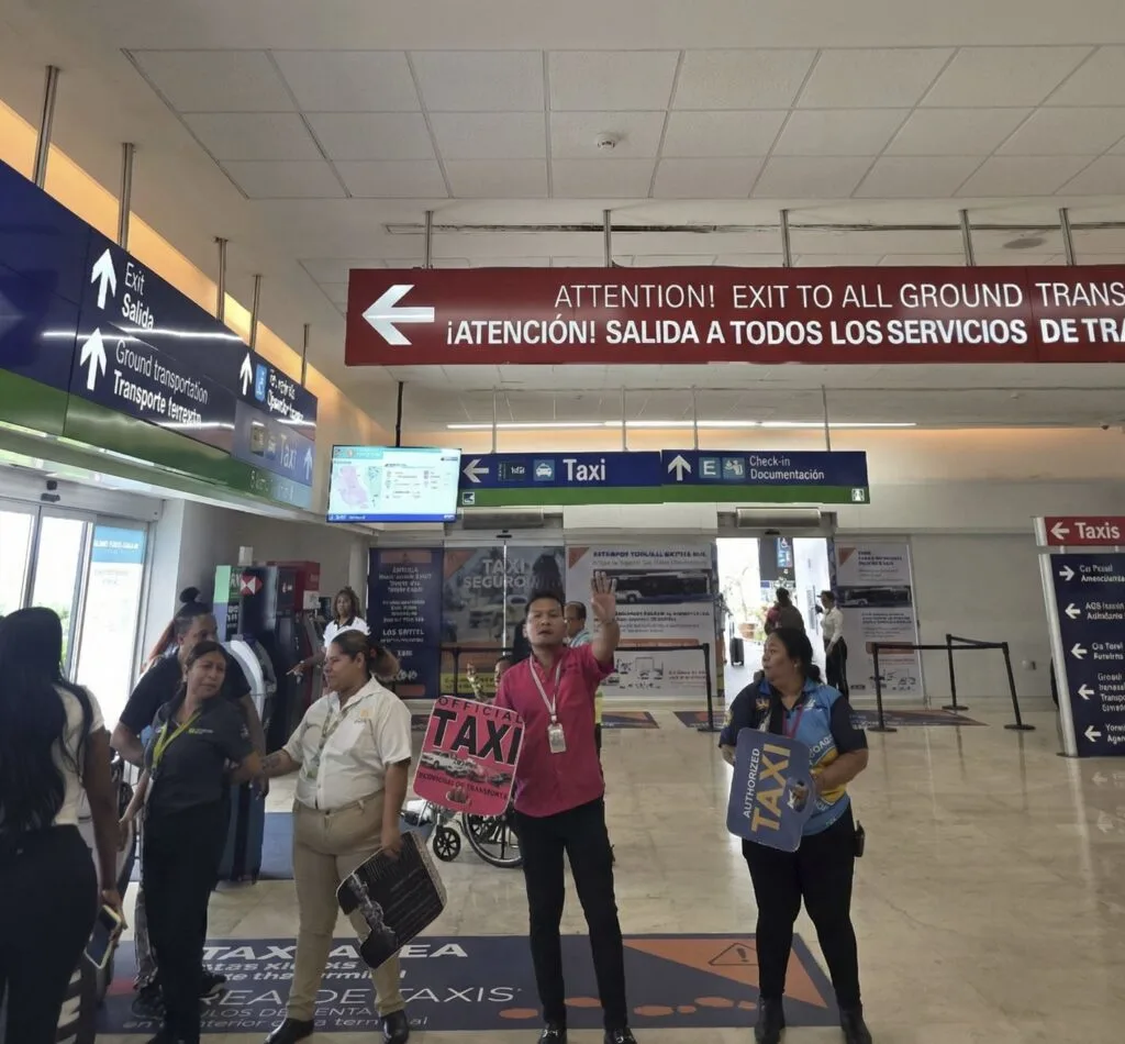 Taxi Drivers Trying to Get rides inside Cancun Airport after shark tank near exit. Original Photo By The Cancun Sun