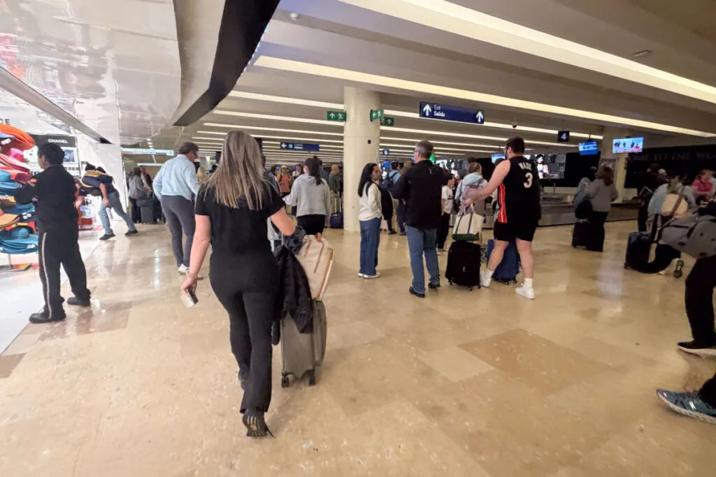 Woman walking through Cancun Airport Luggage area with a carry on only