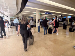 Woman walking through Cancun Airport Luggage area with a carry on only