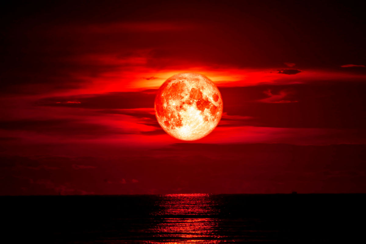 Blood moon over ocean